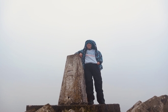 Donna at a trig point in a WILDFundraiser t-shirt. 