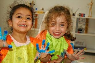 two children painting with their hands