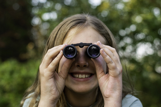 Young girl looking through binoculars