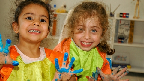 two children painting with their hands