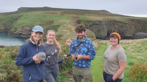 4 young people on Young Birders' Week. Two of them are holding Manx Shearwater chicks.