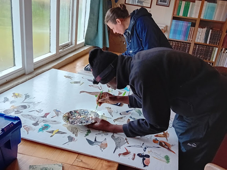 A man painting a bird. 